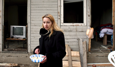 A girl stands in front of her shabby house in Skopje on Friday 23 February 2007.