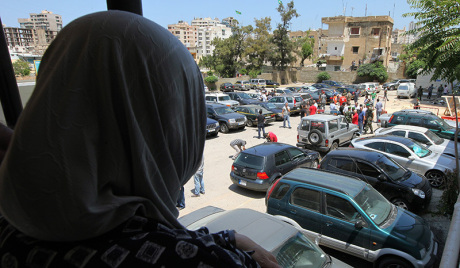 Lebanese policemen inspect a damaged car after a small explosion