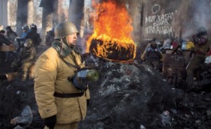 Припадник опозиције поред запаљених буради у центру Кијева